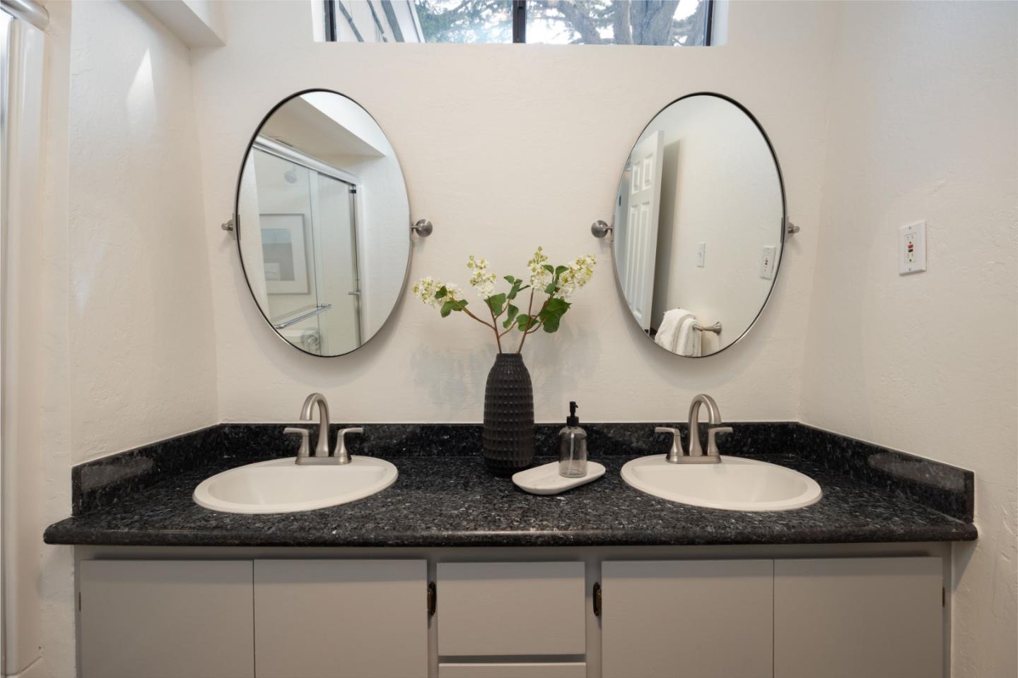 314 Roosevelt Boulevard Half Moon Bay, CA 94019 - Photo 30 of 58 a bathroom with a granite countertop double sink and a mirror