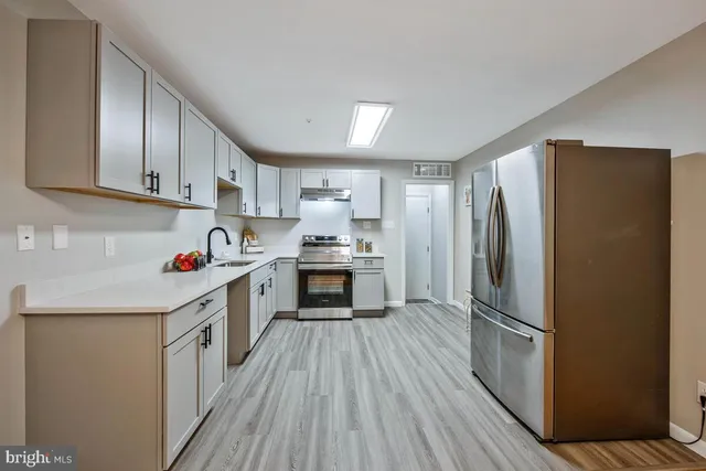 a kitchen with a refrigerator a sink and cabinets
