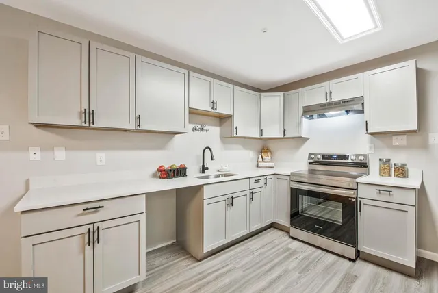 a kitchen with a sink cabinets and wooden floor