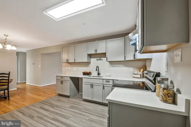 a kitchen with a sink a stove and cabinets