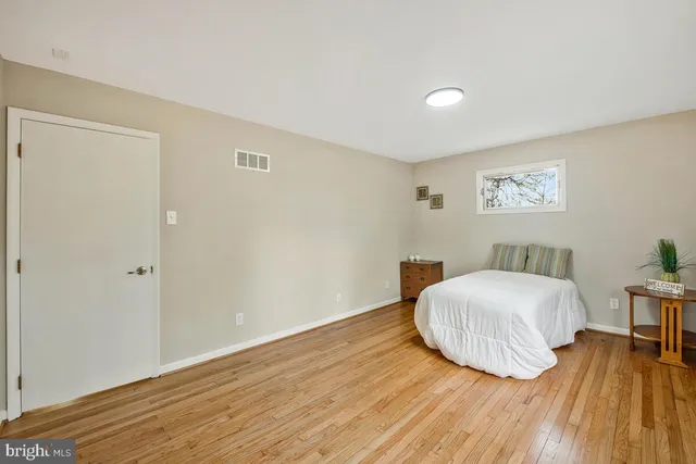 a room with a bed and wooden floor