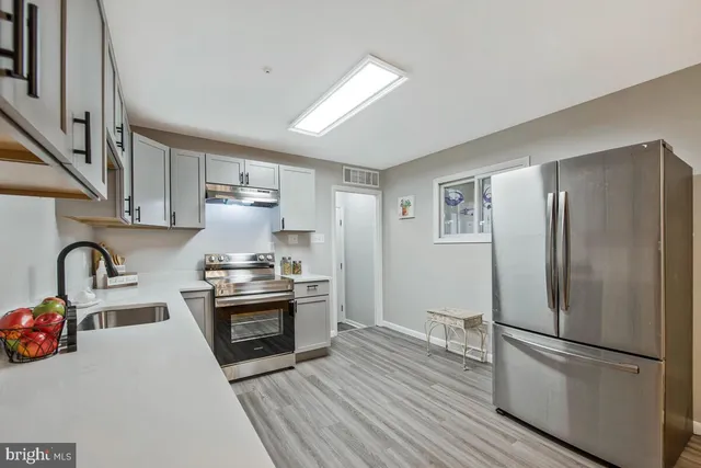 a kitchen with stainless steel appliances granite countertop a refrigerator sink and stove