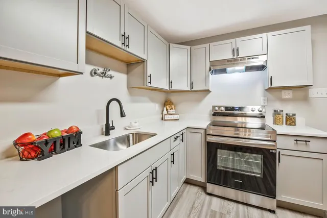 a kitchen with stainless steel appliances granite countertop a sink stove and cabinets