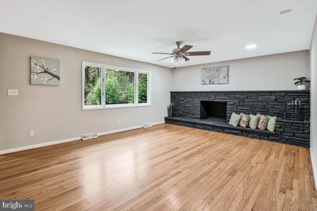 a view of wooden floor fire place refrigerator and window in a room