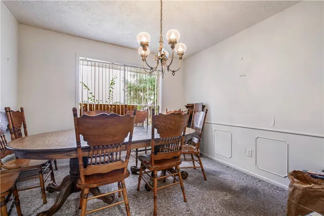 a view of a dining room with furniture and chandelier