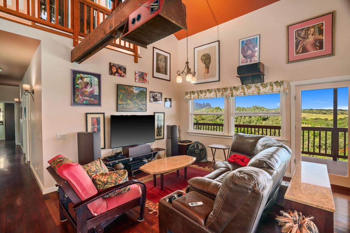5241 Wili Road Kapaa, HI 96746 - Photo 8 of 28 a living room with furniture a flat screen tv and a floor to ceiling window