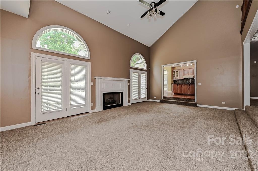 6430 Waters Edge Drive Midland, NC 28107 - Photo 11 of 48 an empty room with windows fireplace and fan