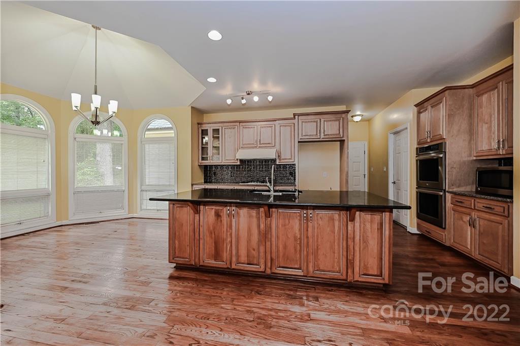 6430 Waters Edge Drive Midland, NC 28107 - Photo 13 of 48 a large kitchen with stainless steel appliances a large counter top a stove and a refrigerator