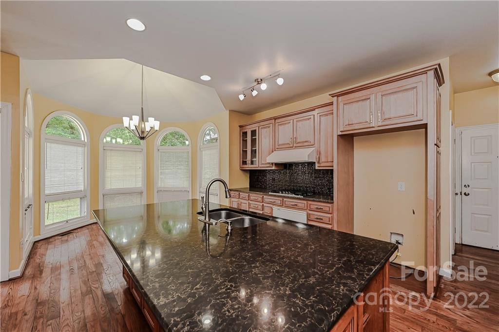 6430 Waters Edge Drive Midland, NC 28107 - Photo 14 of 48 a kitchen with stainless steel appliances granite countertop a stove a sink and a wooden cabinets
