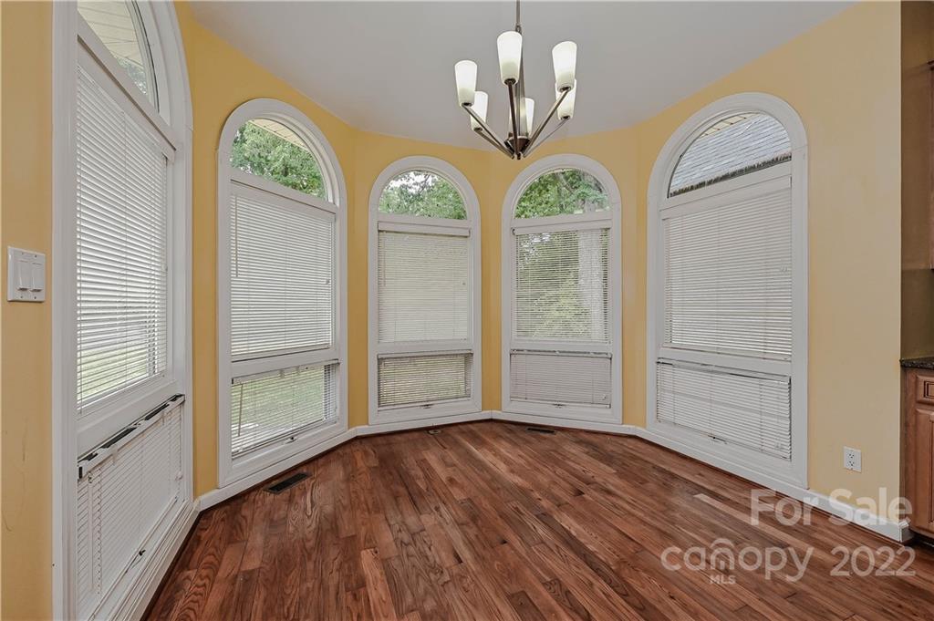 6430 Waters Edge Drive Midland, NC 28107 - Photo 15 of 48 an empty room with wooden floor chandelier and windows