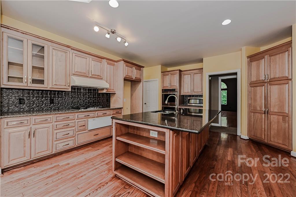 6430 Waters Edge Drive Midland, NC 28107 - Photo 17 of 48 a kitchen with stainless steel appliances kitchen island granite countertop a stove and cabinets