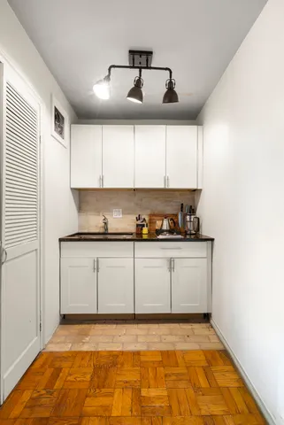 a view of kitchen with granite countertop white cabinets and black appliances