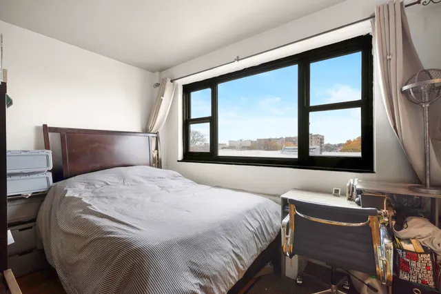 a bedroom with a bed and a large window with outer view