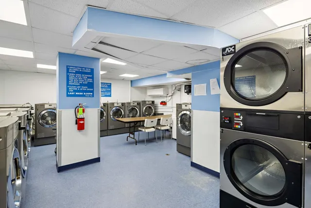 a utility room with dryer washer and a view of living room