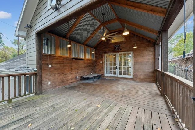 a view of backyard with wooden floor and iron fence