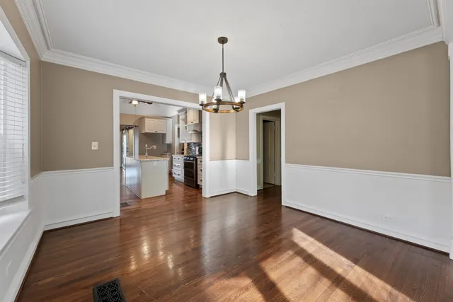a view of a hallway with wooden floor and a chandelier