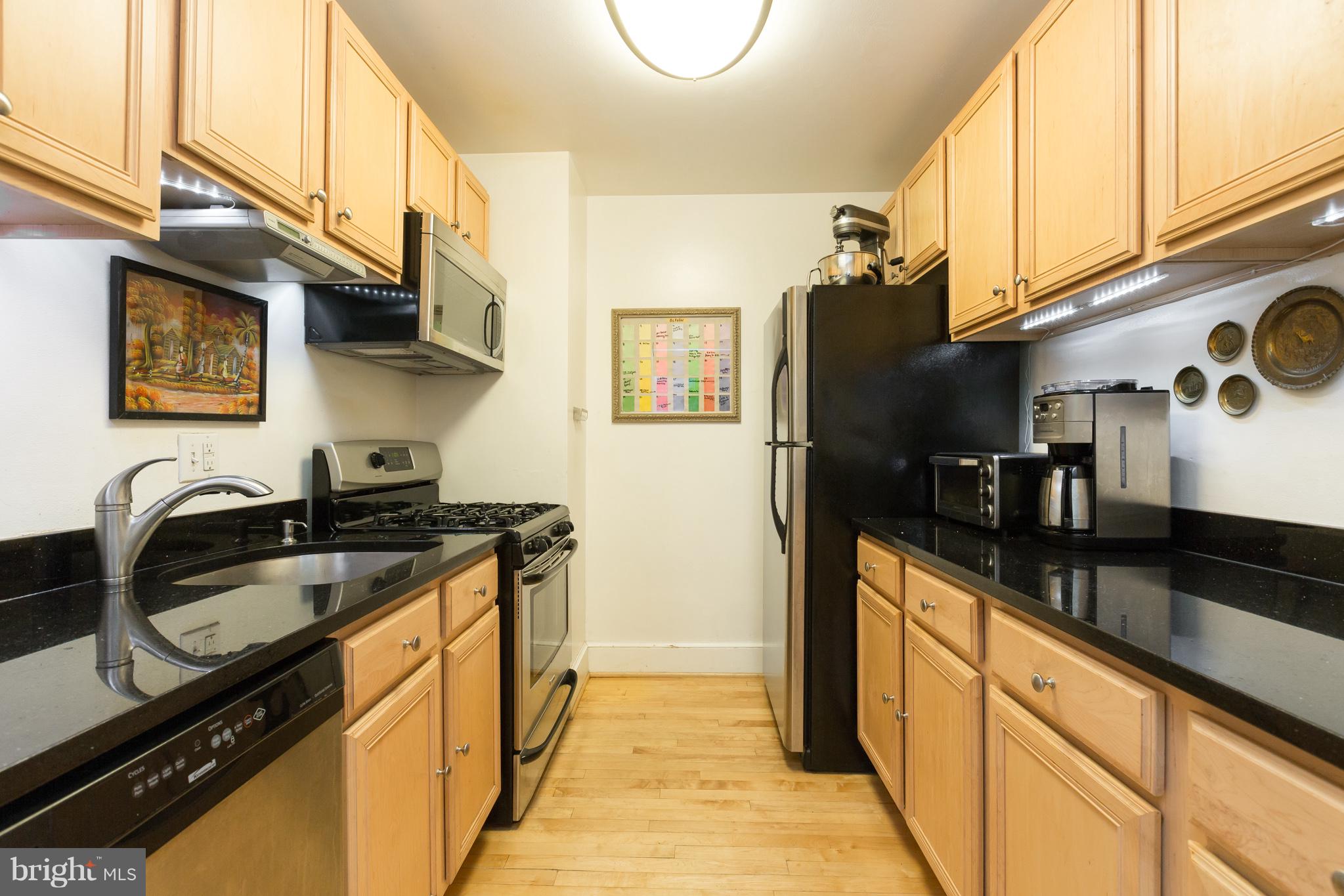 3060 16th Street Northwest, Unit 102 Washington, DC 20009 - Photo 5 of 17 a kitchen with granite countertop stainless steel appliances a sink stove top oven and cabinets