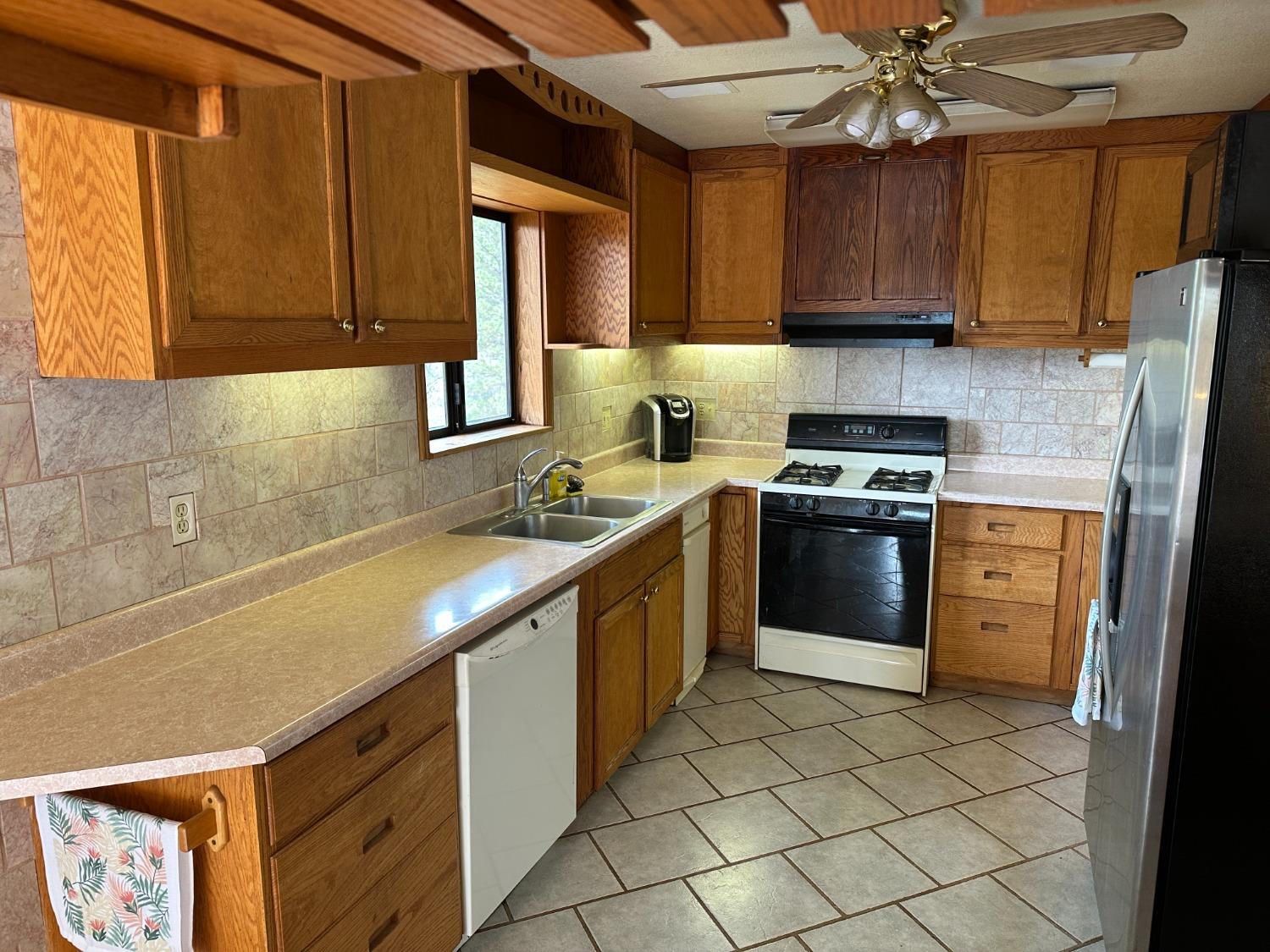 4368 Eazy Bird Road Wilseyville, CA 95257 - Photo 15 of 25 a kitchen with stainless steel appliances granite countertop a sink a stove a refrigerator cabinets and a window