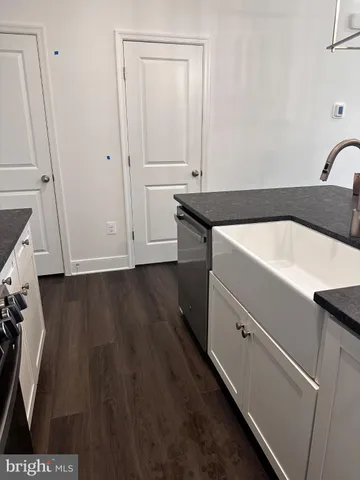 a kitchen with stainless steel appliances a refrigerator and a wooden floor