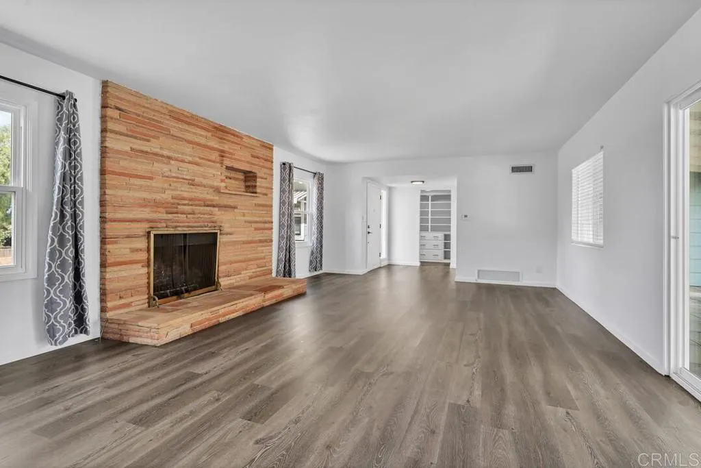 988 Pepper Drive El Cajon, CA 92021 - Photo 16 of 41 an empty room with wooden floor fireplace and windows