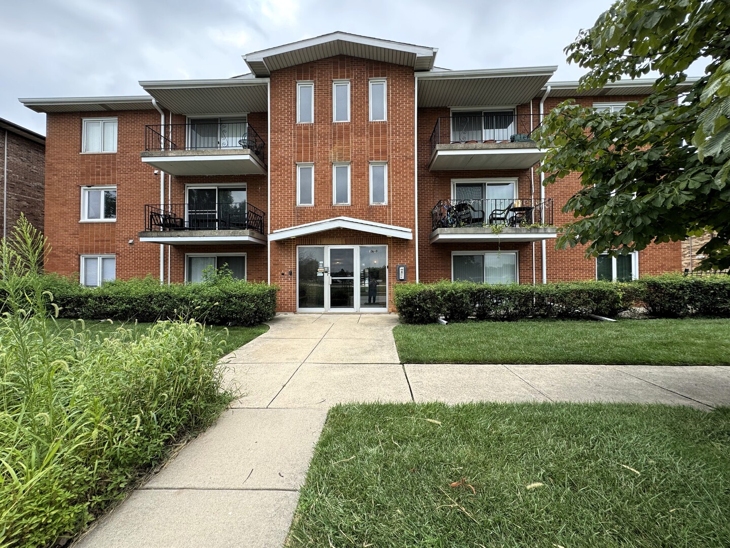 10840 Kilpatrick Avenue, Unit 1NW Oak Lawn, IL 60453 - Photo 1 of 11 a front view of a residential apartment building with a yard
