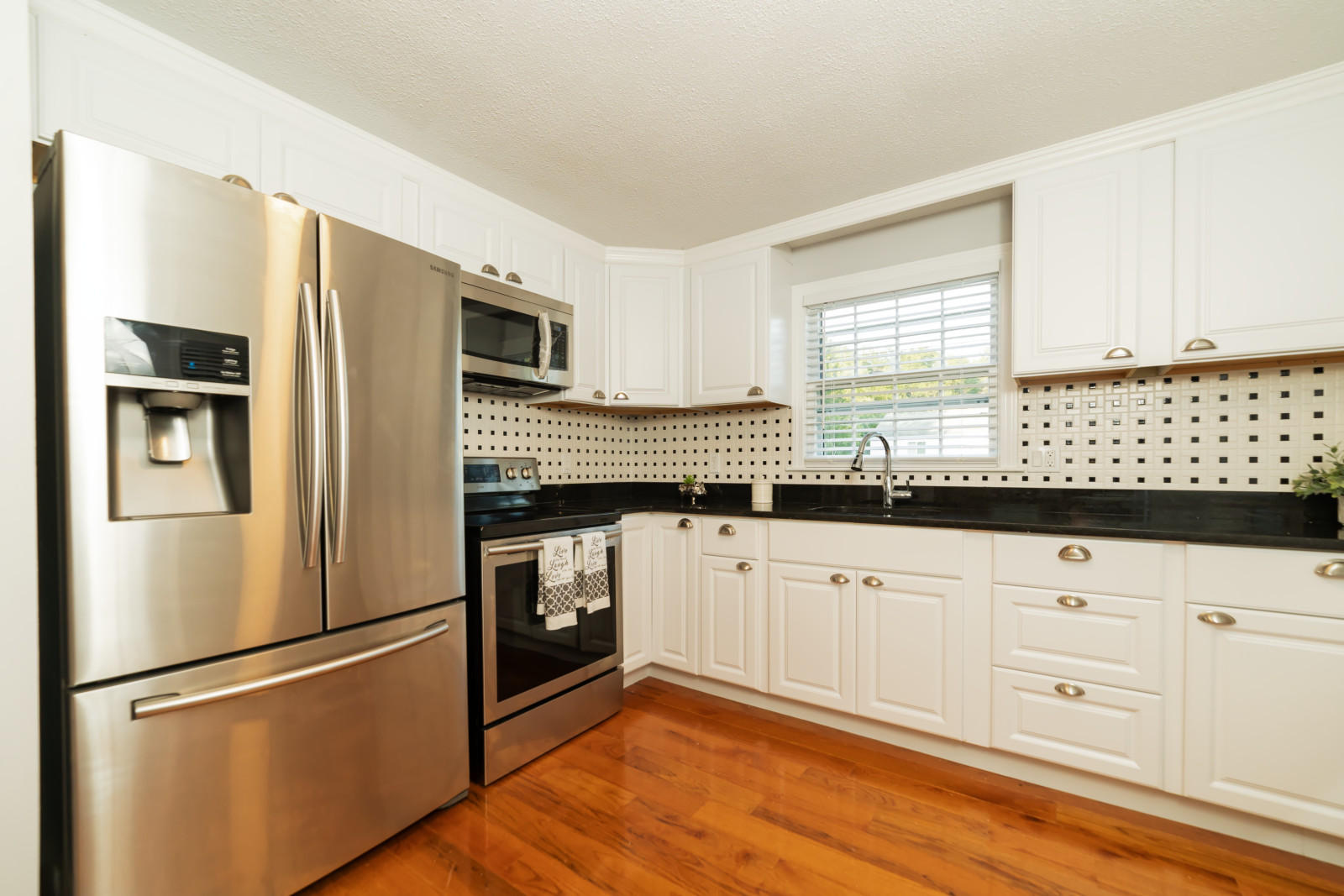 25 Fillmore Road West Yarmouth, MA 02673 - Photo 8 of 23 a kitchen with granite countertop white cabinets and stainless steel appliances