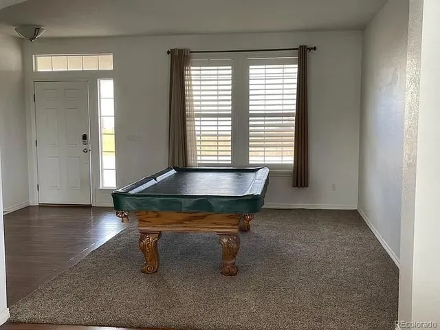 a room with furniture pool table and windows