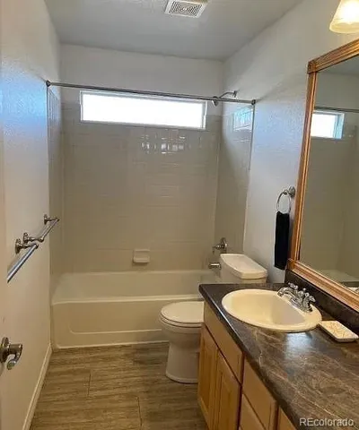 a bathroom with a granite countertop sink toilet and shower