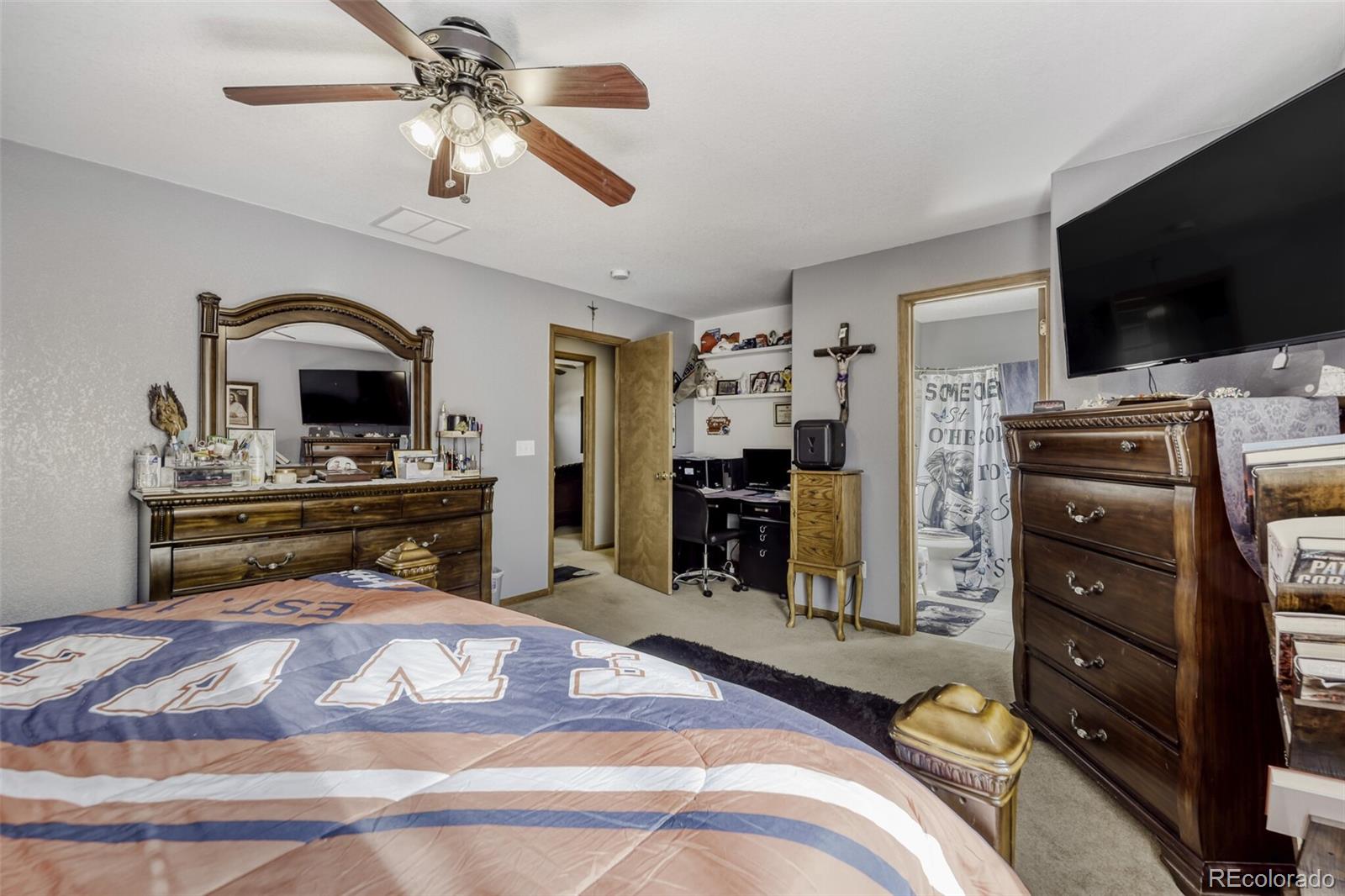 1435 Hummingbird Circle Brighton, CO 80601 - Photo 11 of 22 a bedroom with a bed and a flat screen tv
