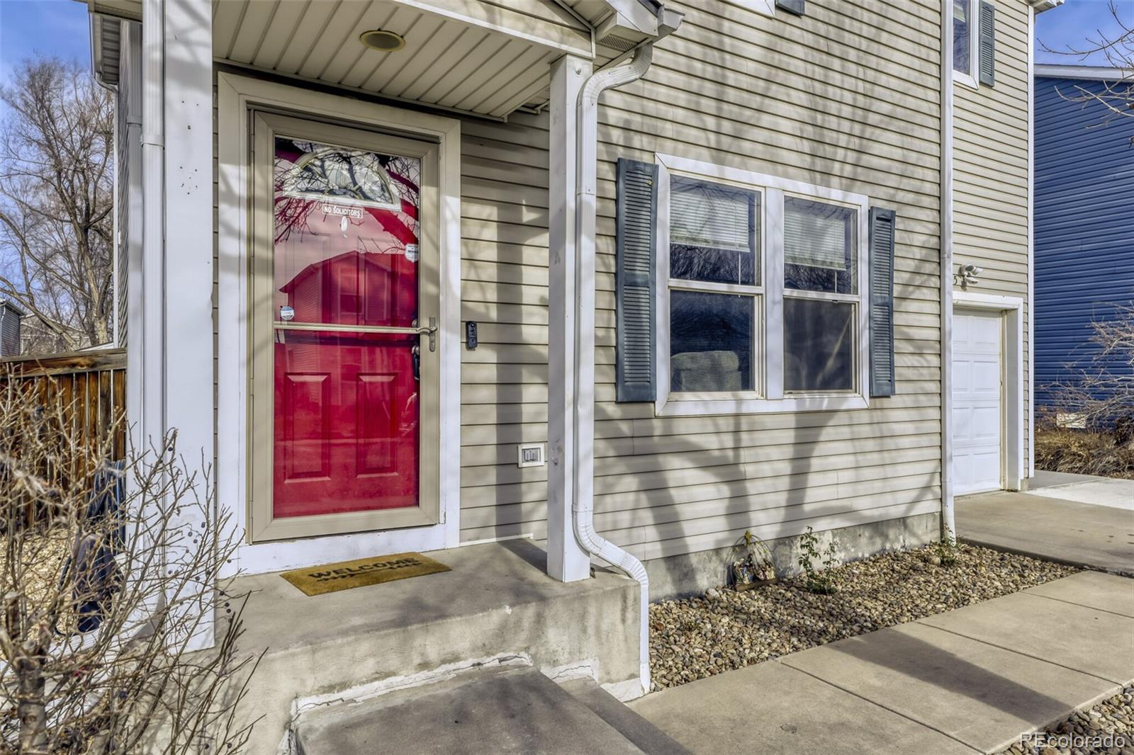 1435 Hummingbird Circle Brighton, CO 80601 - Photo 2 of 22 a front view of a house with red door