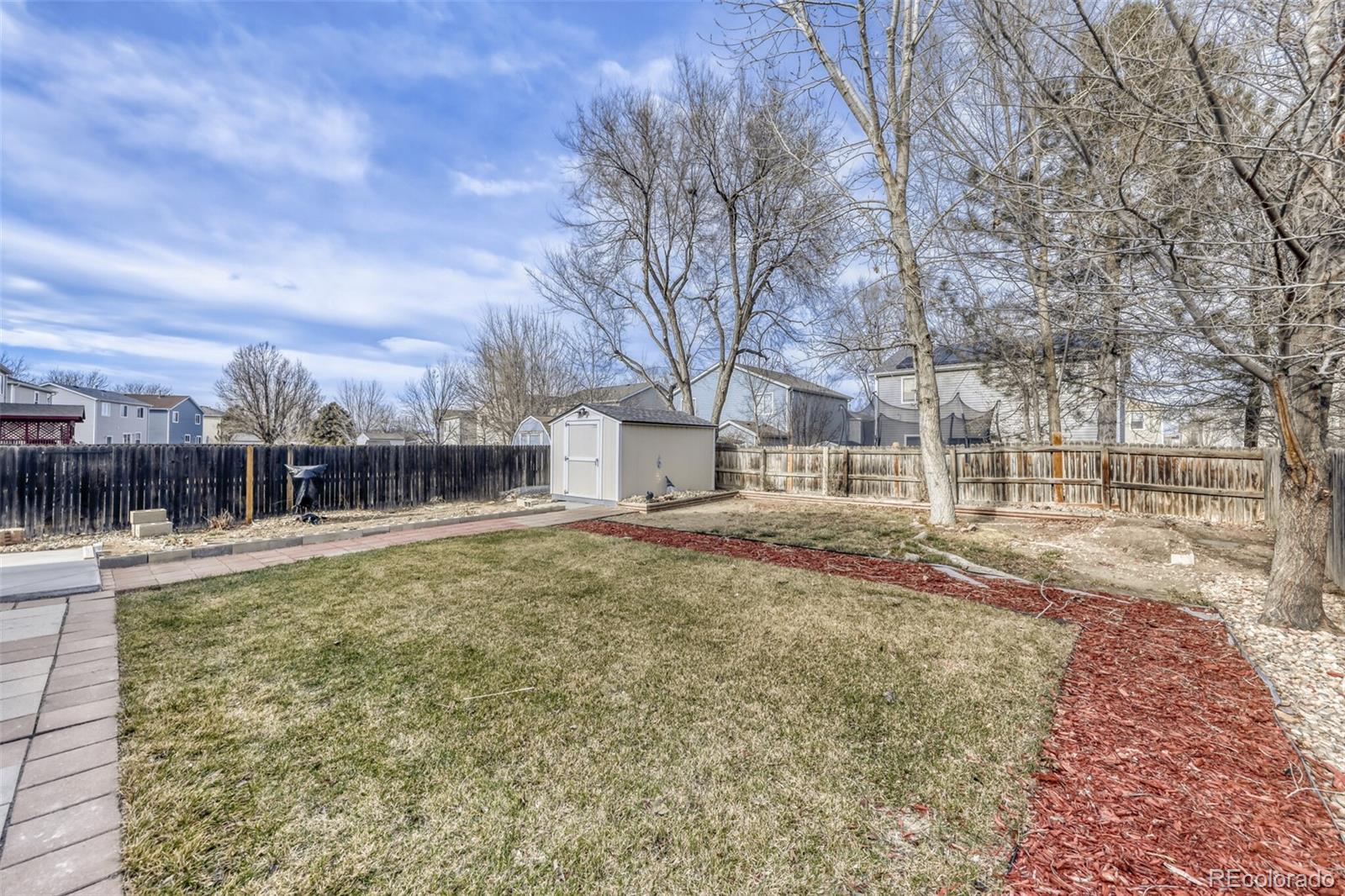 1435 Hummingbird Circle Brighton, CO 80601 - Photo 21 of 22 a view of a large white house with a yard and covered with snow