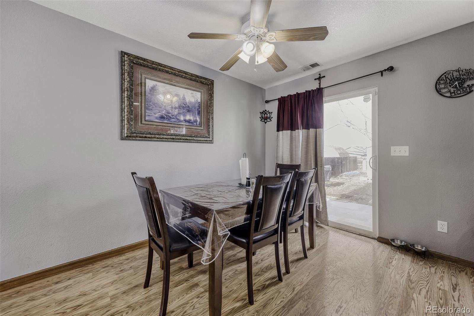 1435 Hummingbird Circle Brighton, CO 80601 - Photo 6 of 22 a view of a dining room with furniture window and wooden floor