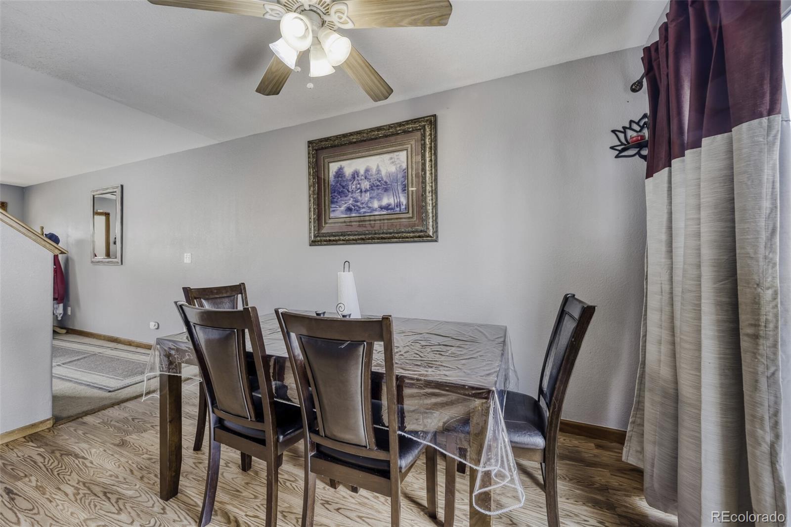 1435 Hummingbird Circle Brighton, CO 80601 - Photo 7 of 22 a view of a dining room with furniture and chandelier