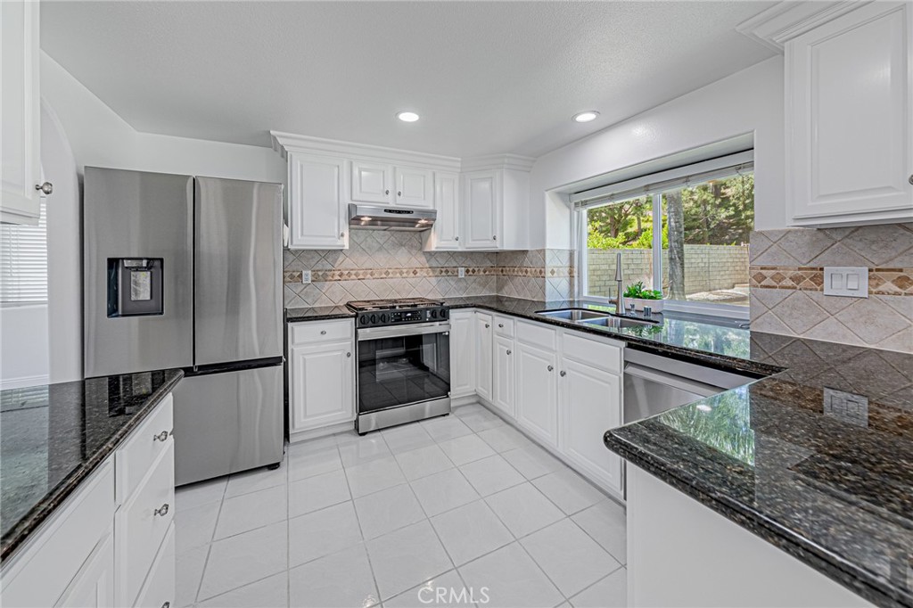 25533 Longfellow Place Stevenson Ranch, CA 91381 - Photo 14 of 47 a kitchen with stainless steel appliances granite countertop a stove a sink and a refrigerator