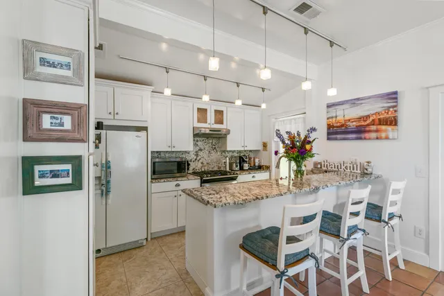 a kitchen with stainless steel appliances granite countertop a refrigerator and a stove top oven