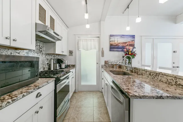 a kitchen with stainless steel appliances granite countertop a stove and a sink