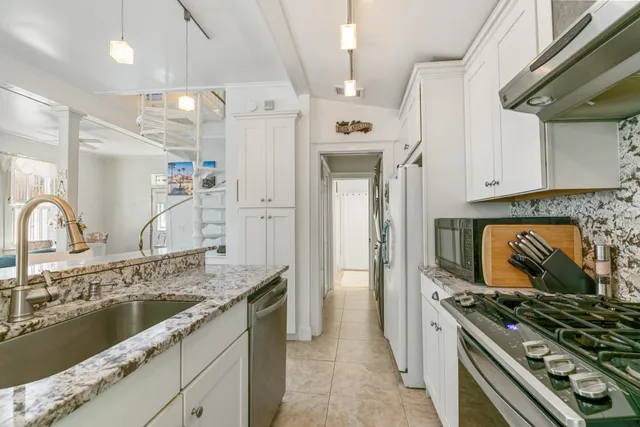 a kitchen with granite countertop a stove and a sink
