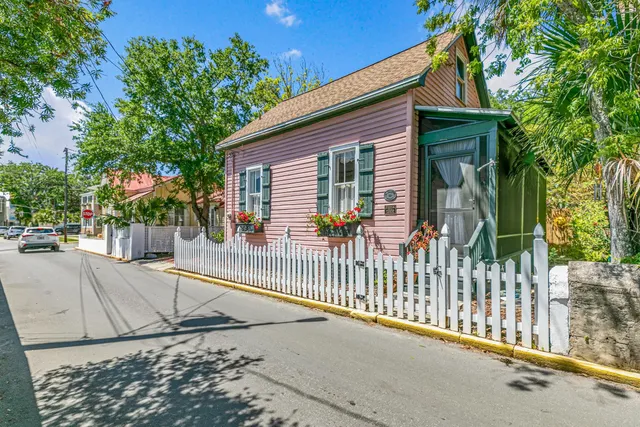 a view of a house with a tree and wooden fence