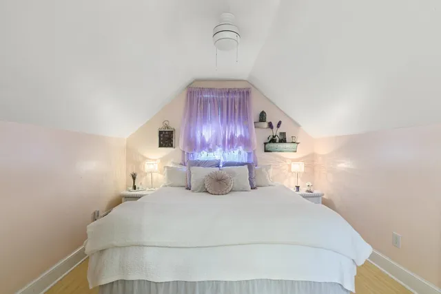 a bedroom with a bed and flat tv screen on the dresser