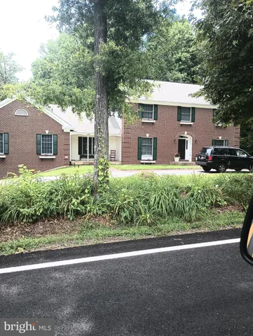 a front view of a house with a yard and potted plants