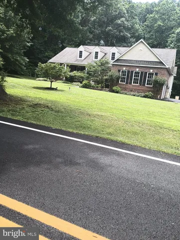 a view of an house with backyard and trees