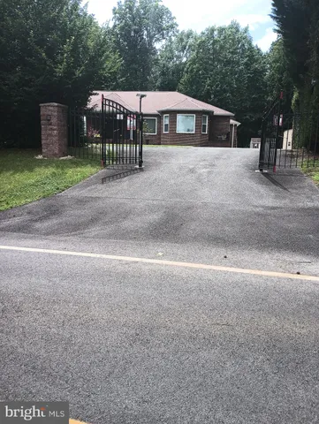 a view of a house with a yard and large trees