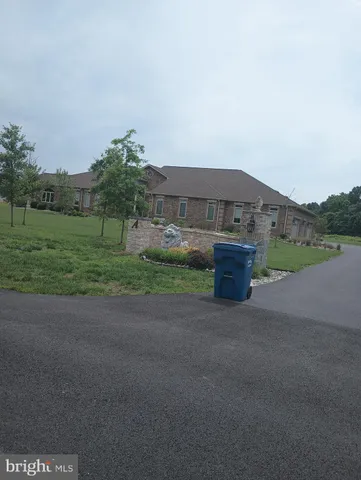 a view of a house with a yard and a large parking space