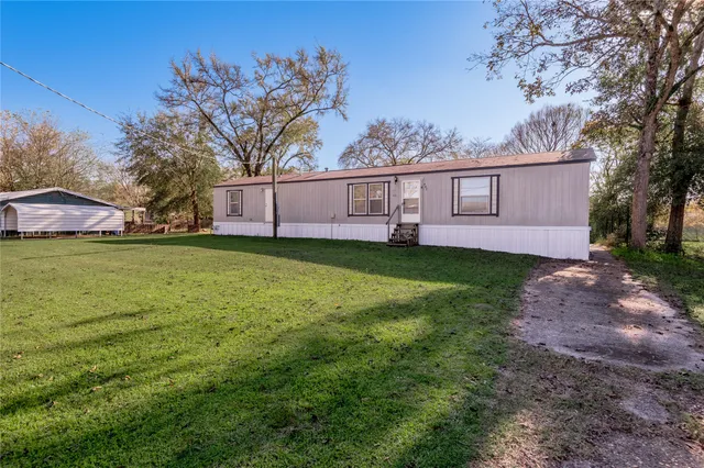 a view of a house with a yard and tree