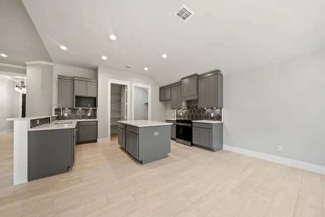 a large kitchen with a large counter top stainless steel appliances and cabinets