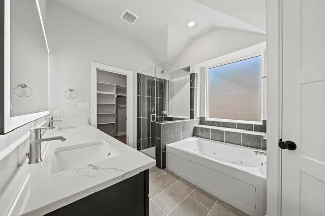 a bathroom with a tub a sink and a large mirror