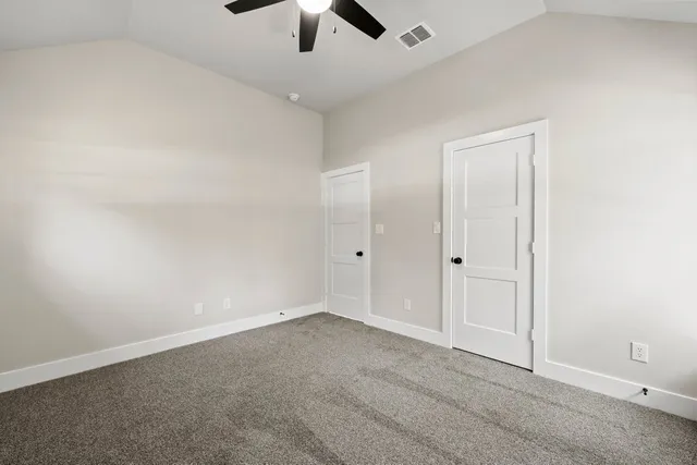 an empty room with chandelier fan