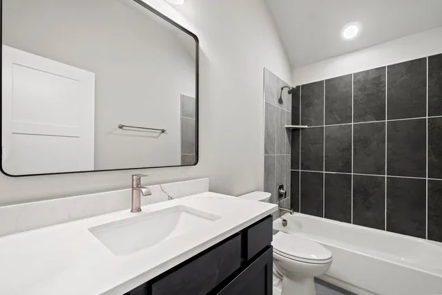 a bathroom with a sink toilet vanity and shower