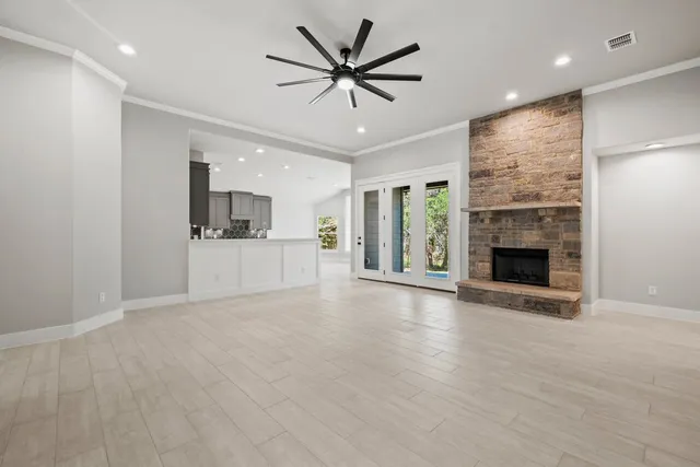 an empty room with kitchen and a fireplace