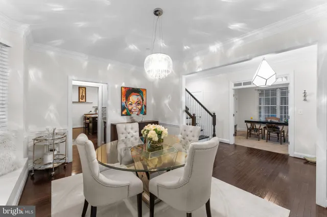 a dining room with furniture large windows and wooden floor